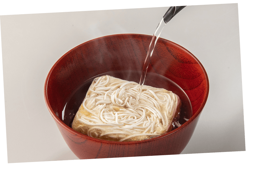 商品画像：フリーズドライにゅうめんにお湯を注いでいる